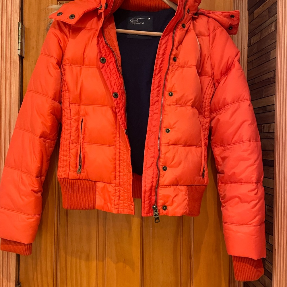 American Eagle Outfitters orange puffer jacket.